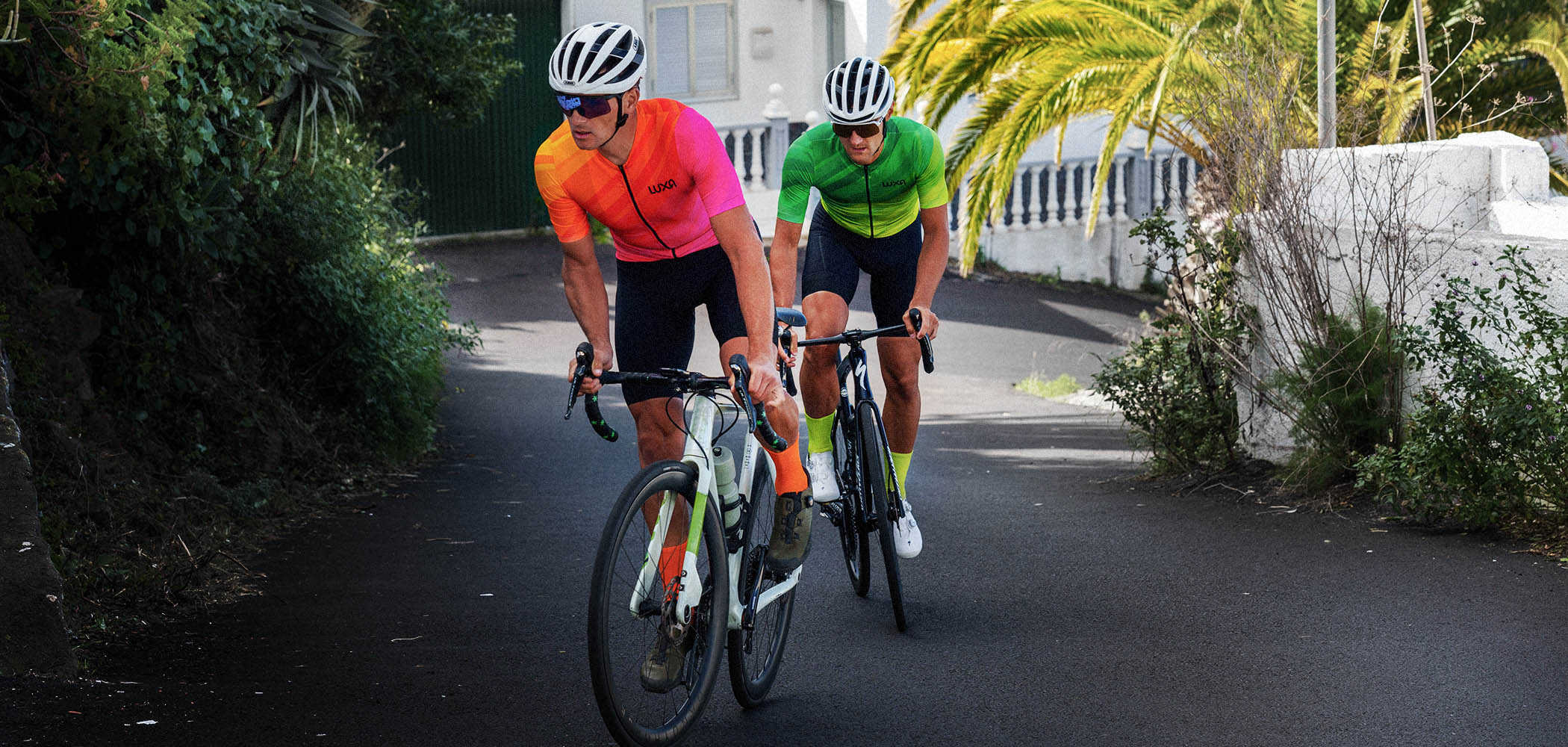 Cyclists dressed in Luxa cycling uniforms wear matching cycling socks in the same colors